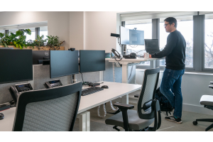man standing at height adjustable desk