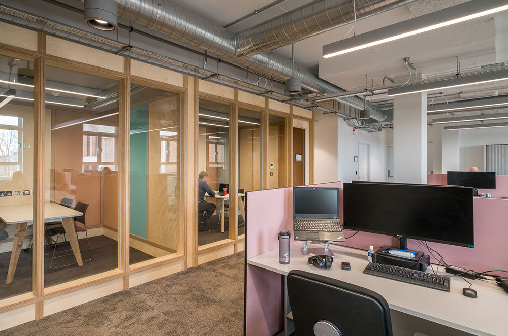 open plan office with a row of telephone pod booths