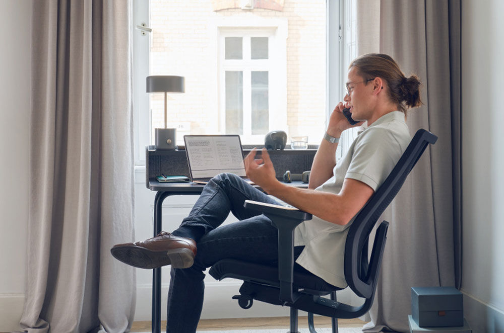 man sitting in a task chair at a desk at home